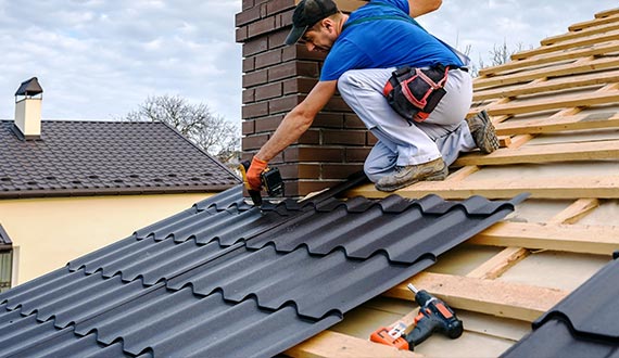 a professional roofing master covers the roof residential building