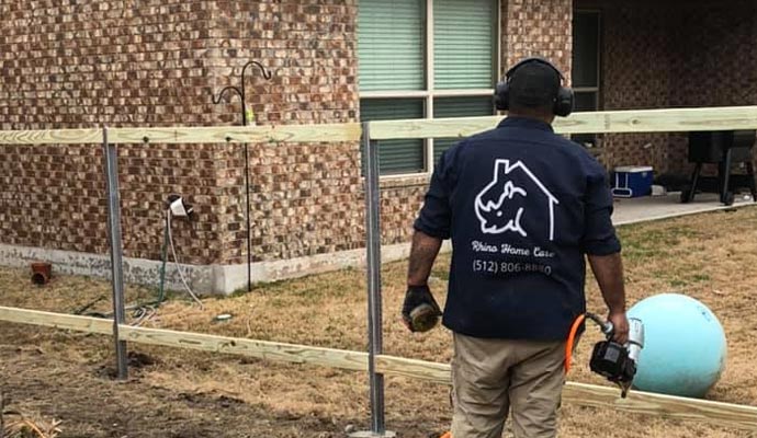 A person installing a fence using equipment