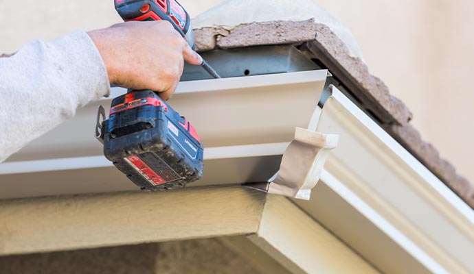 Professional worker restoring clogged gutter