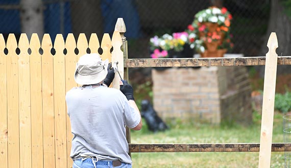 manual worker repair the wood fence in the yard