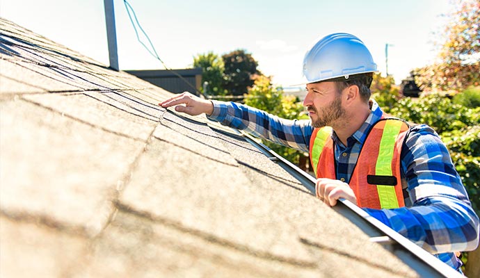 Professional worker inspecting roof tile