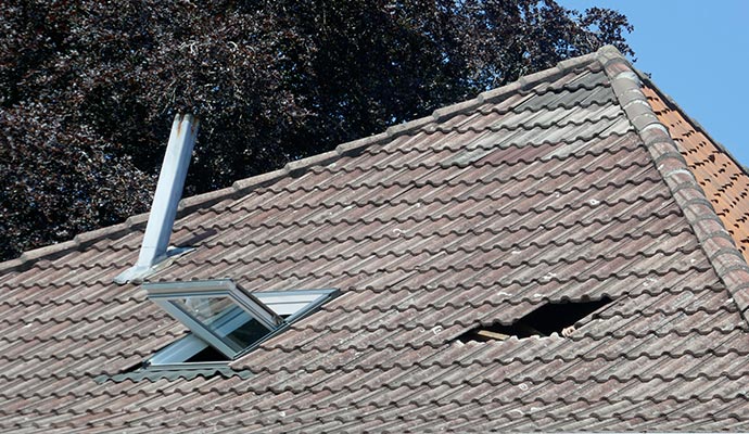 roof hole damage in the hous broken tile roof after a storm