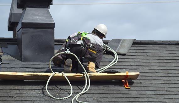 roof repair and maintenance construction worker roofer man roofing security rope