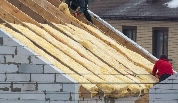 Person installing roof insulation