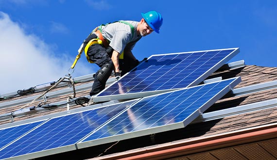 technician installing solar panels residential home