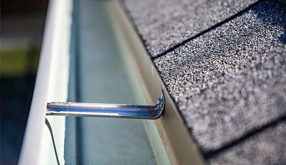 view inside roof gutter with clips and edge of shingles