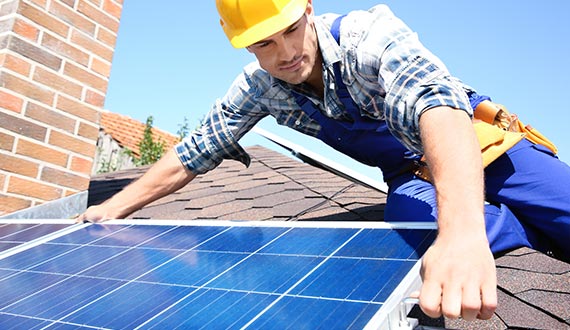 worker installing solar panels residential home outdoors