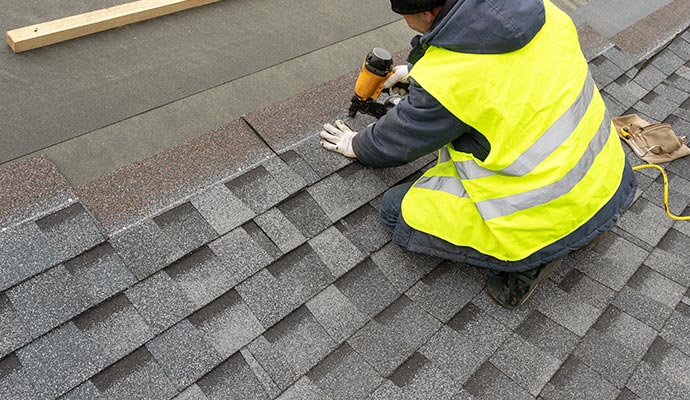 Worker repairing wind damaged roof